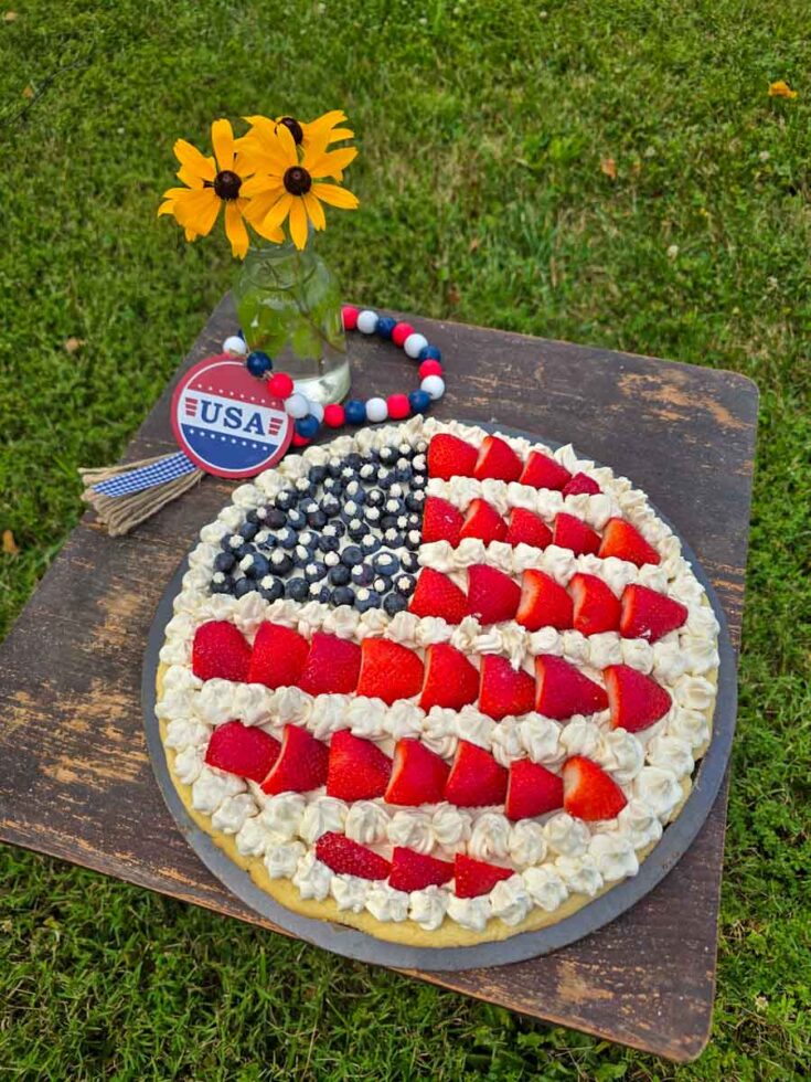 patriotic fruit pizza on table with jar of black-eyed susans