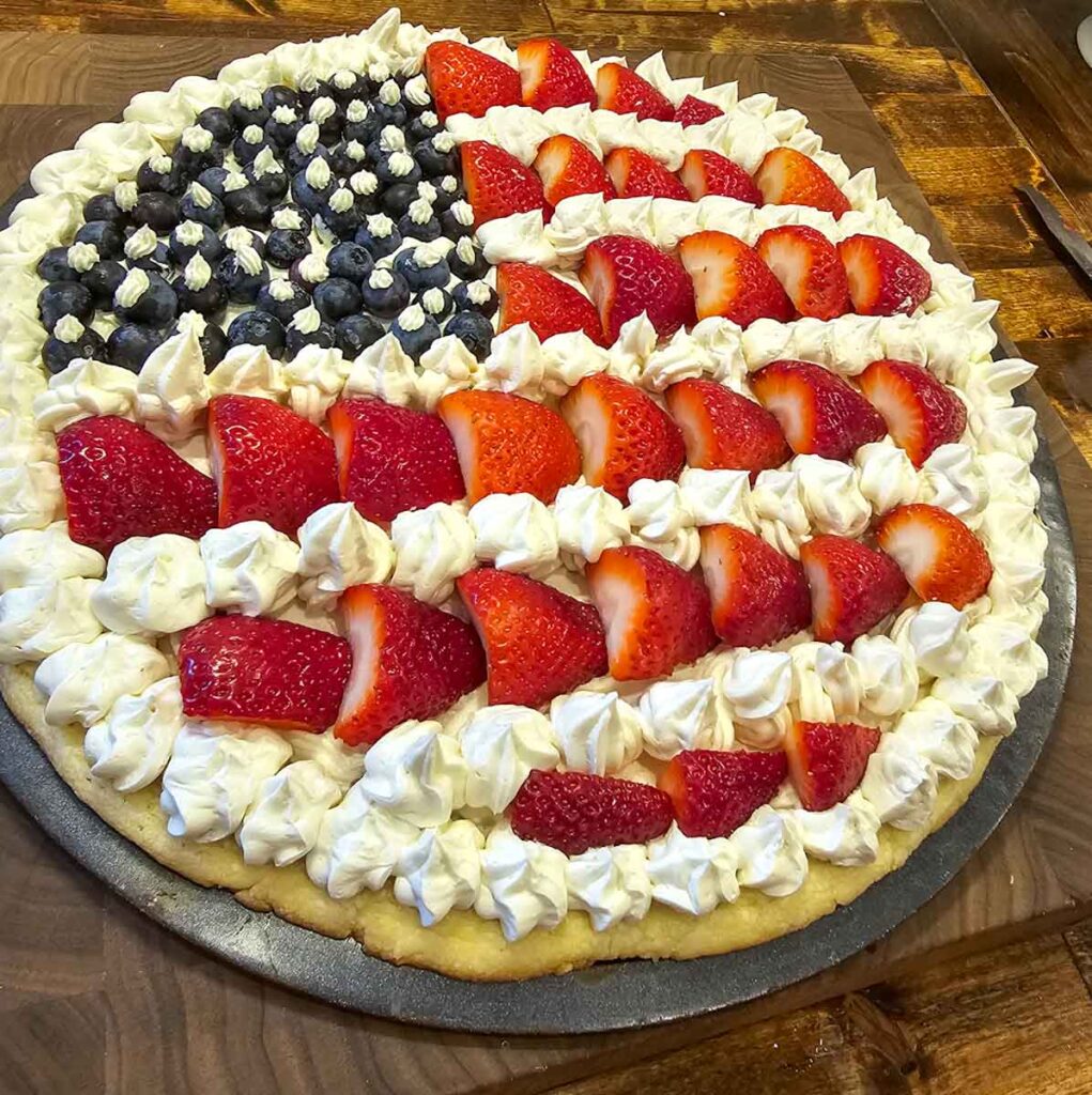 Completed fruit pizza with strawberries and blueberries
